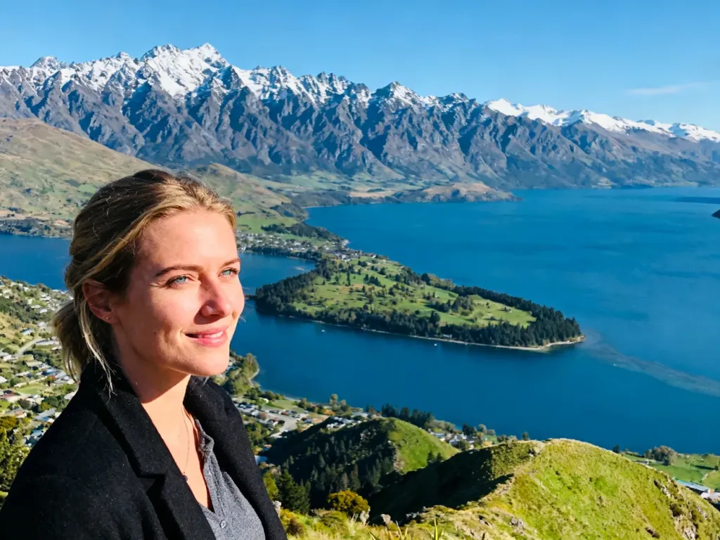 Turystka podziwiająca panoramę Queenstown, jezioro Wakatipu oraz ośnieżone szczyty gór Remarkables w Nowej Zelandii.